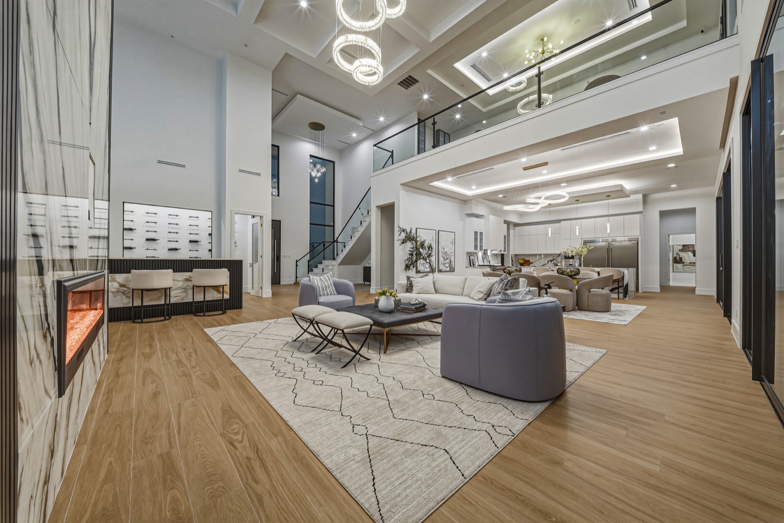 Bright double-height interior with a long fireplace and sculptural lights