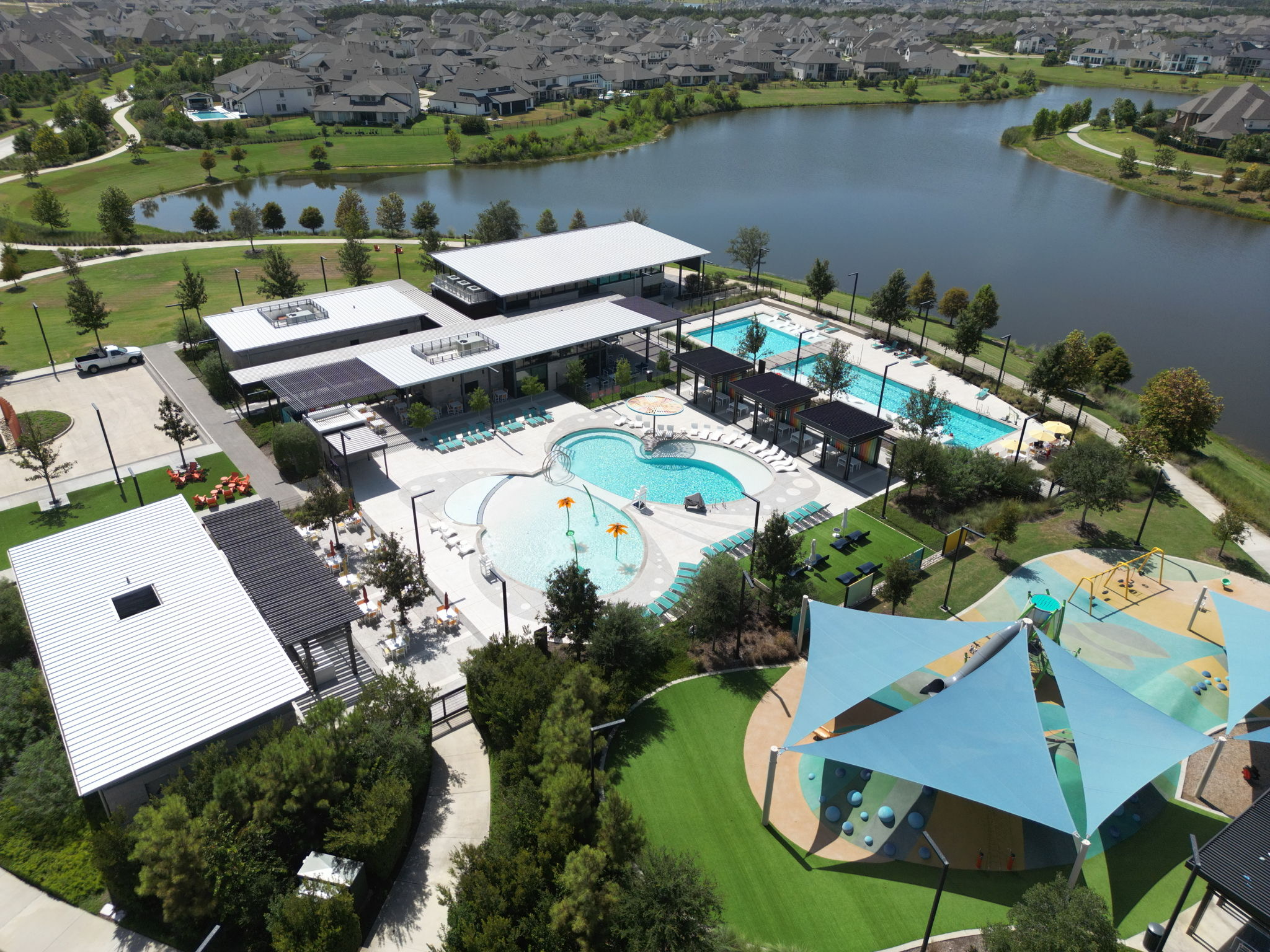 Aerial view of a lakeside recreation center with swimming pools and play areas