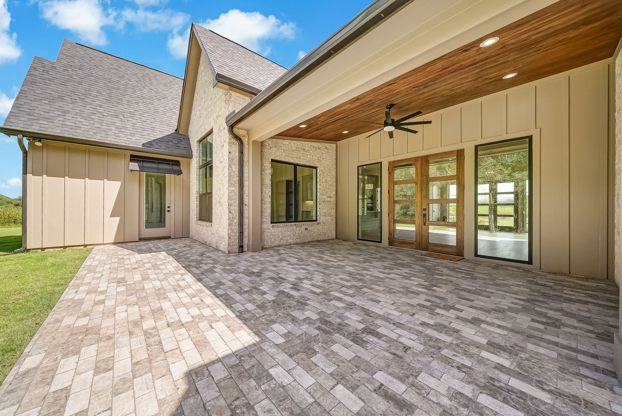 Covered rear terrace with brick columns and stone pavers