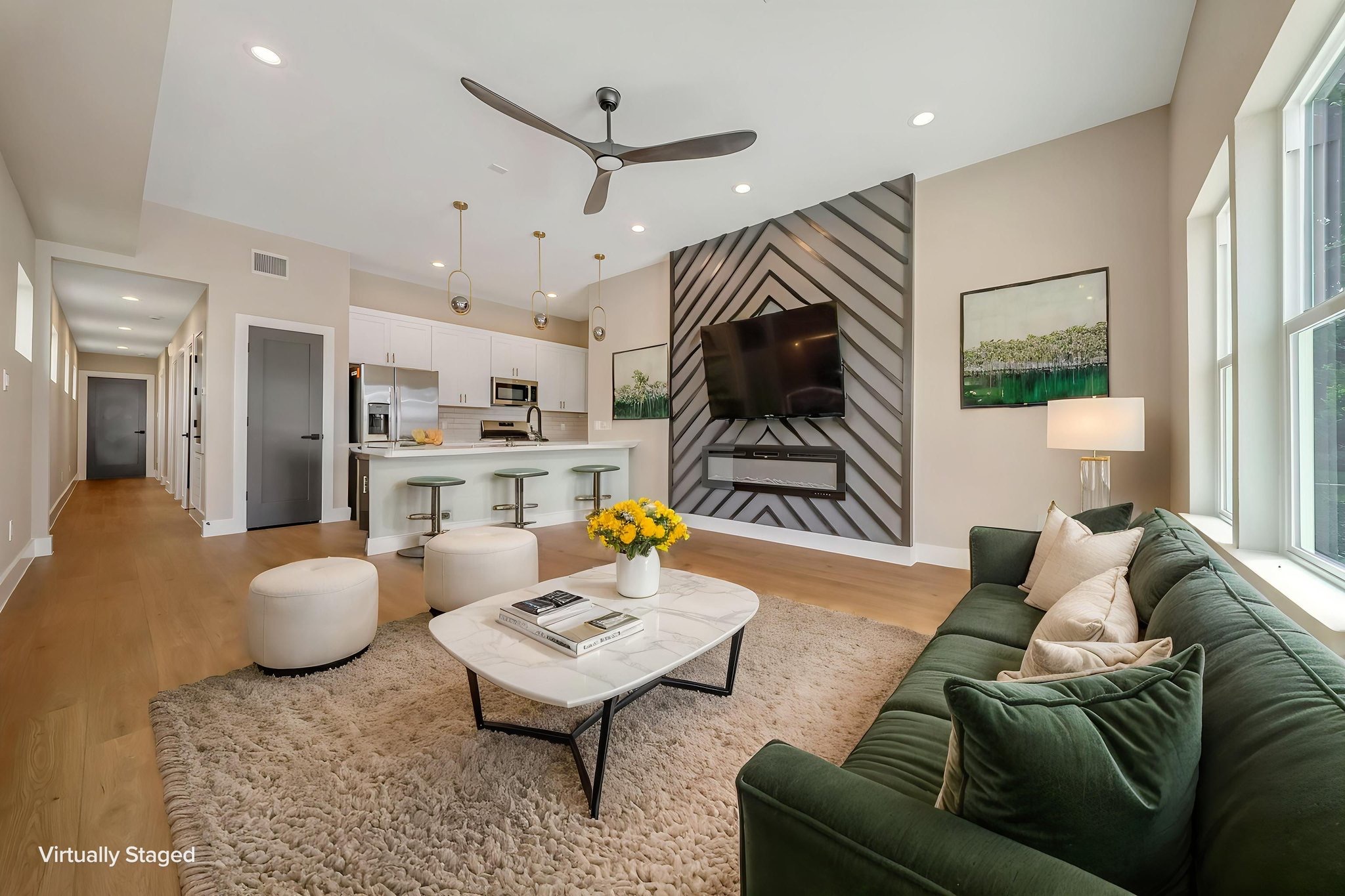 Living area with patterned wall, sofa, and an open kitchen