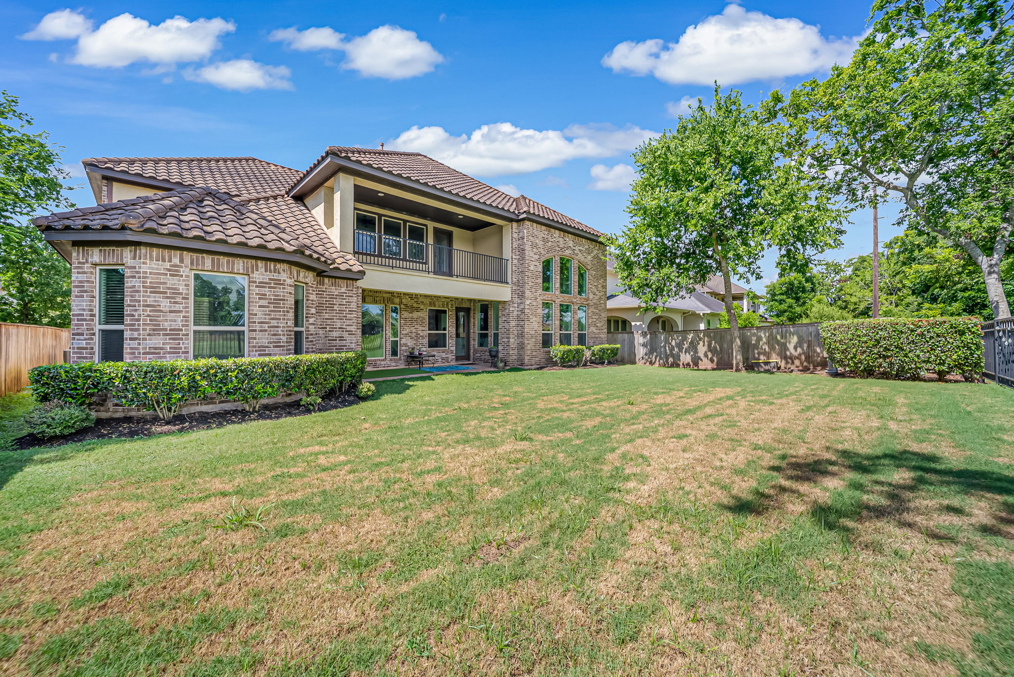 Brick residence seen across an open green lawn