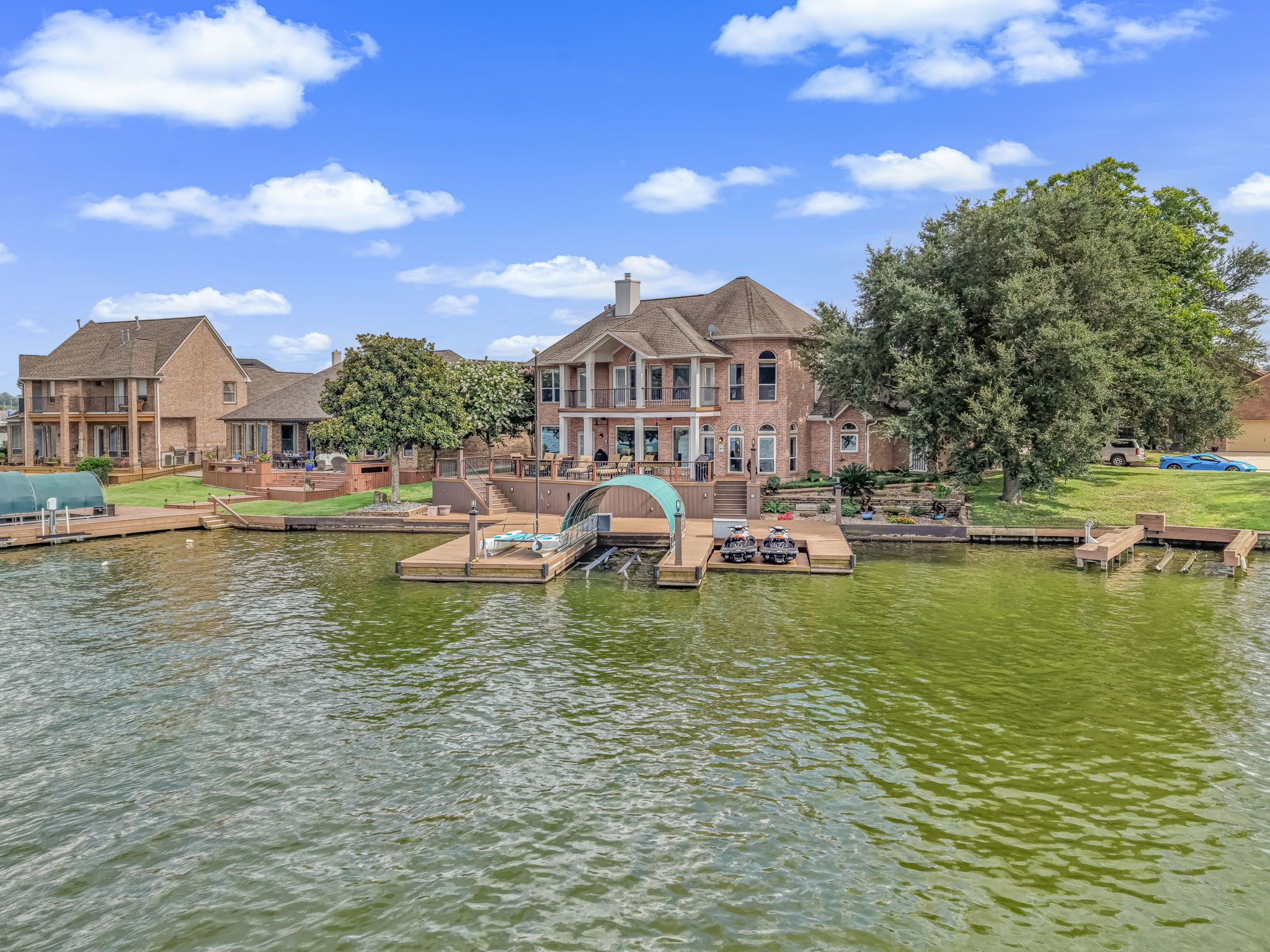 Elevated view of a brick waterfront home with private boat docks