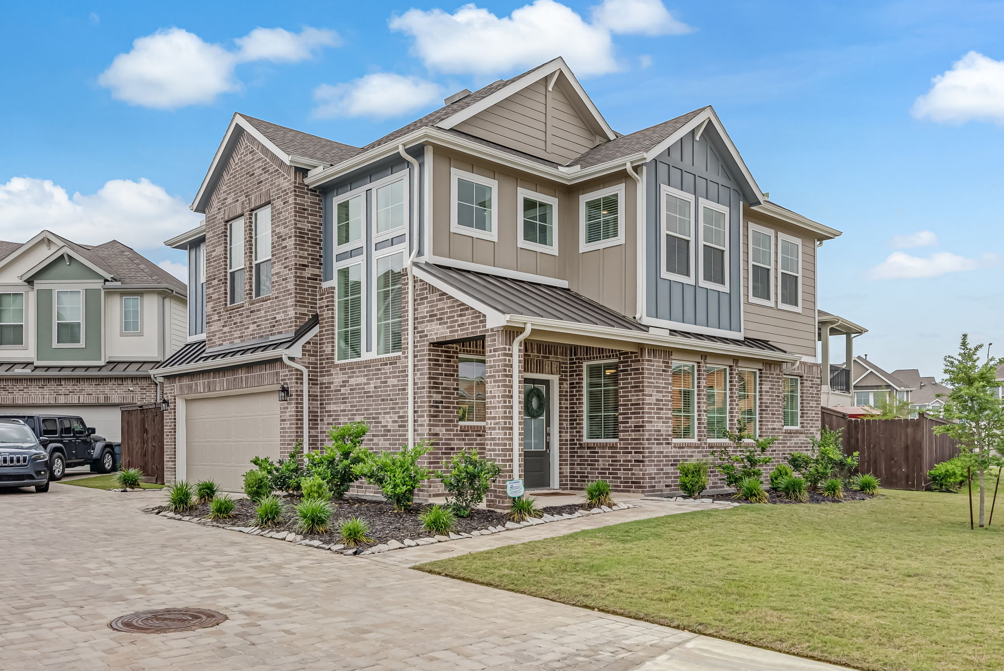 Two-story home with stone and siding exterior viewed from the driveway