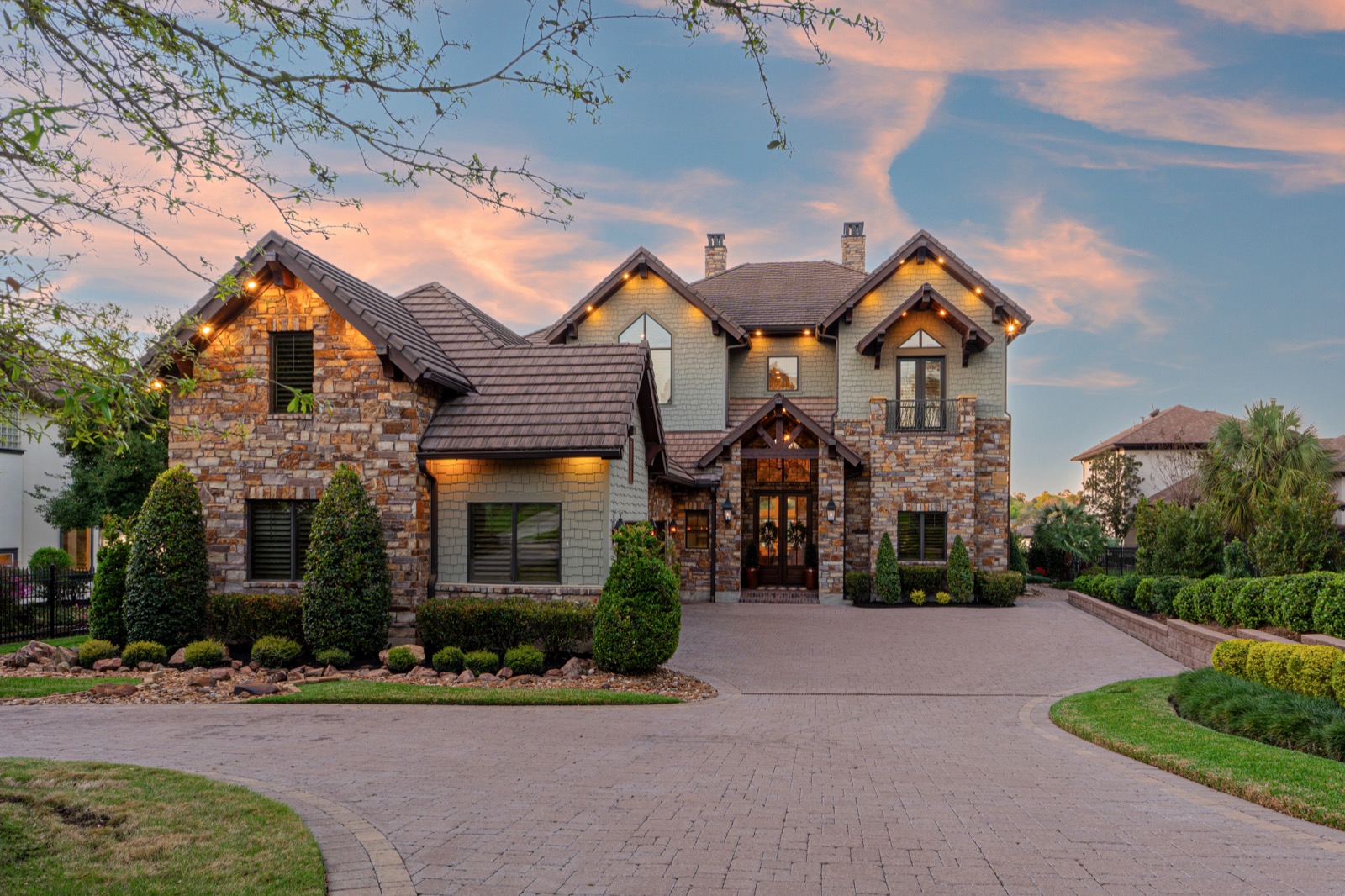 Stone residence framed by a dramatic evening sky