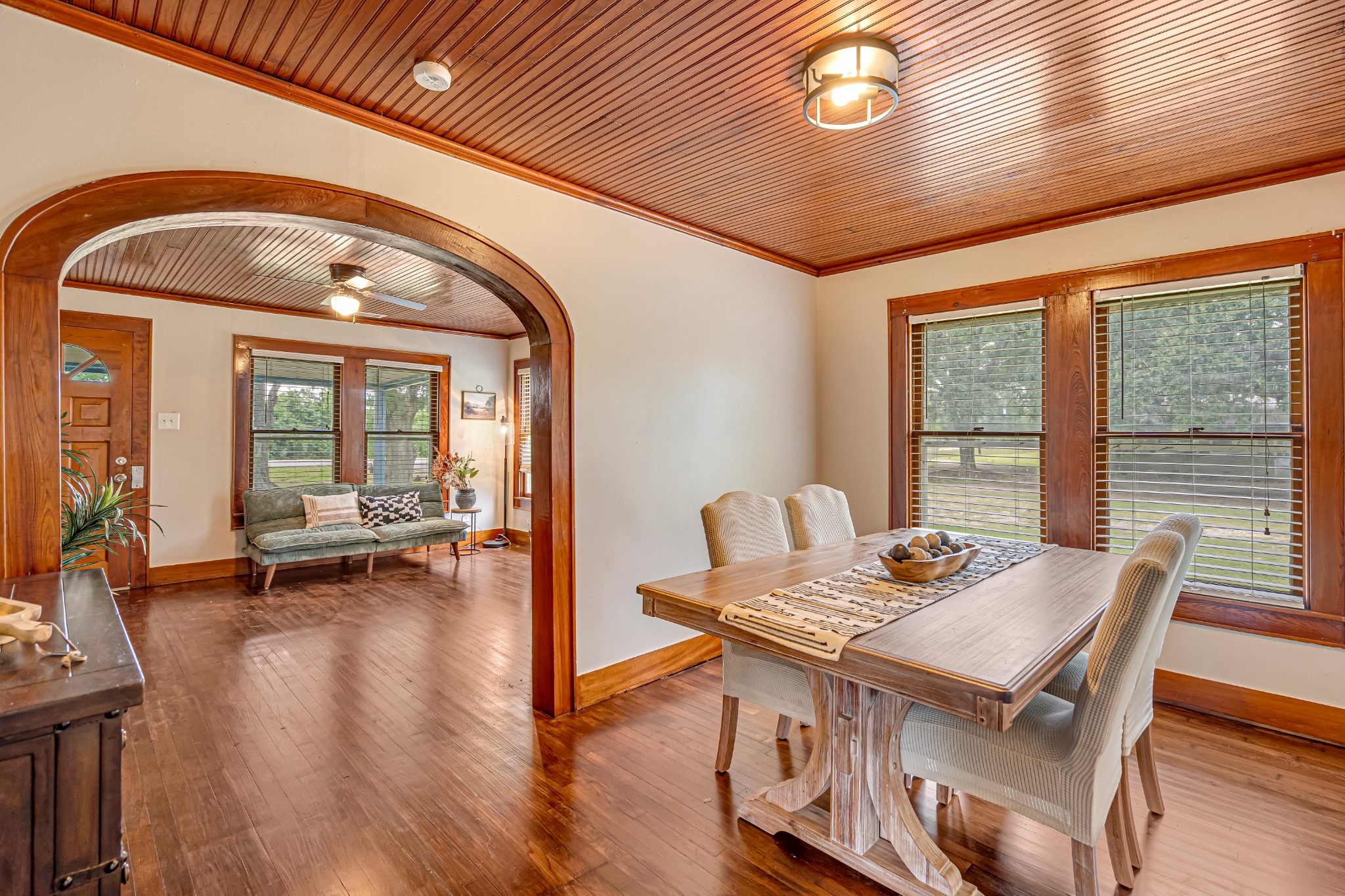 Dining room with an arched opening and wood plank ceiling