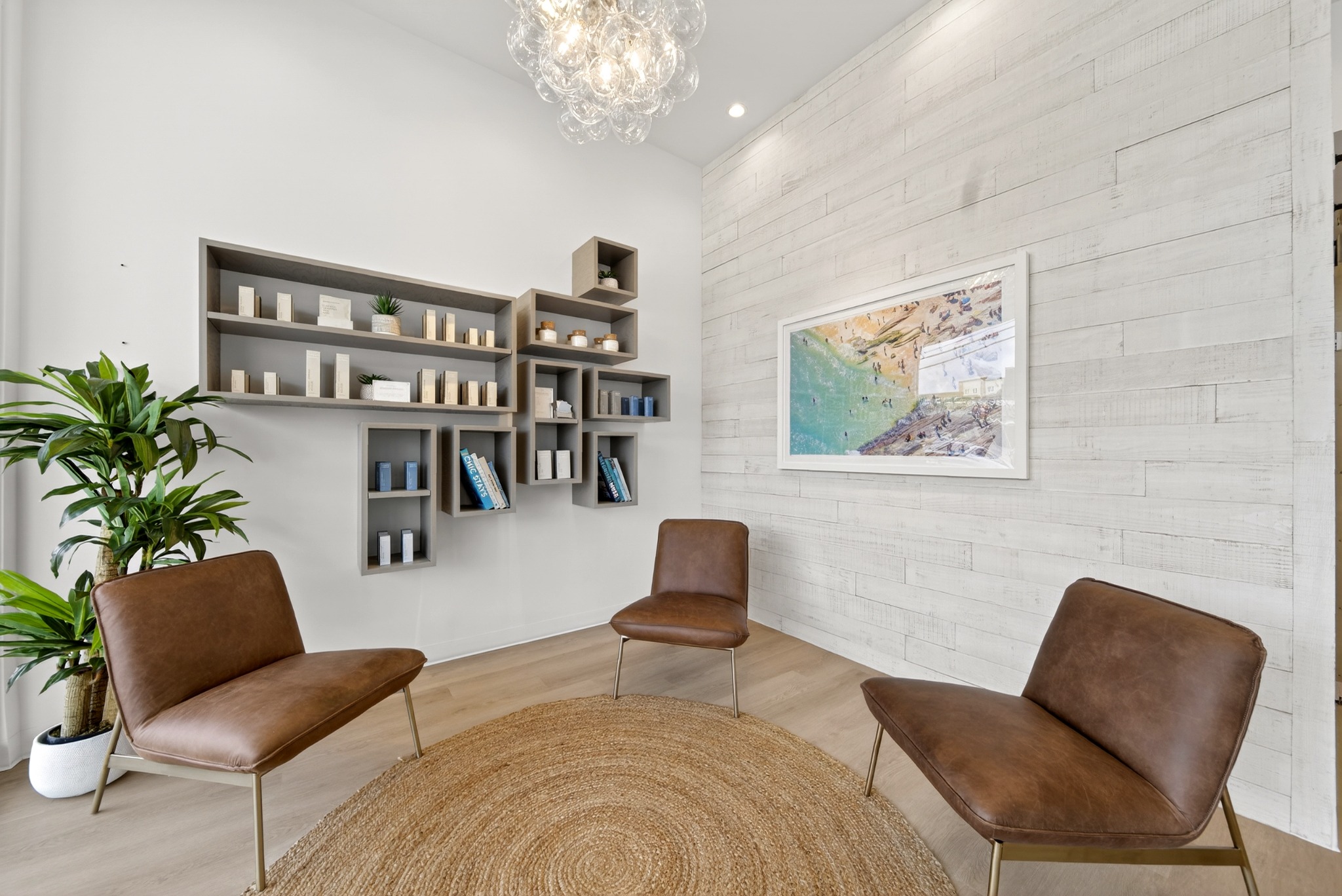 Waiting lounge with leather chairs, display shelves, and artwork