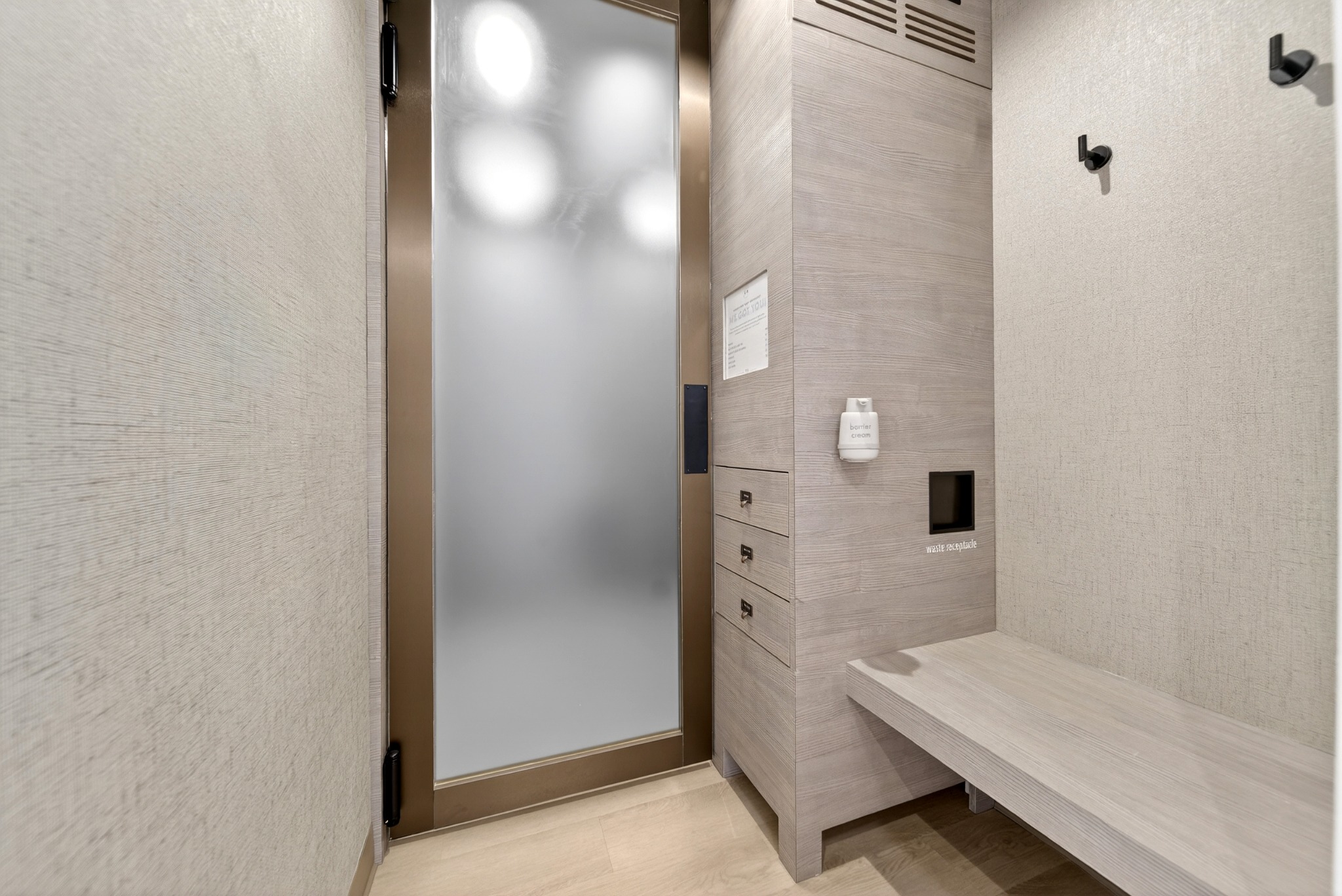 Tiled shower suite with a bench and illuminated mirror