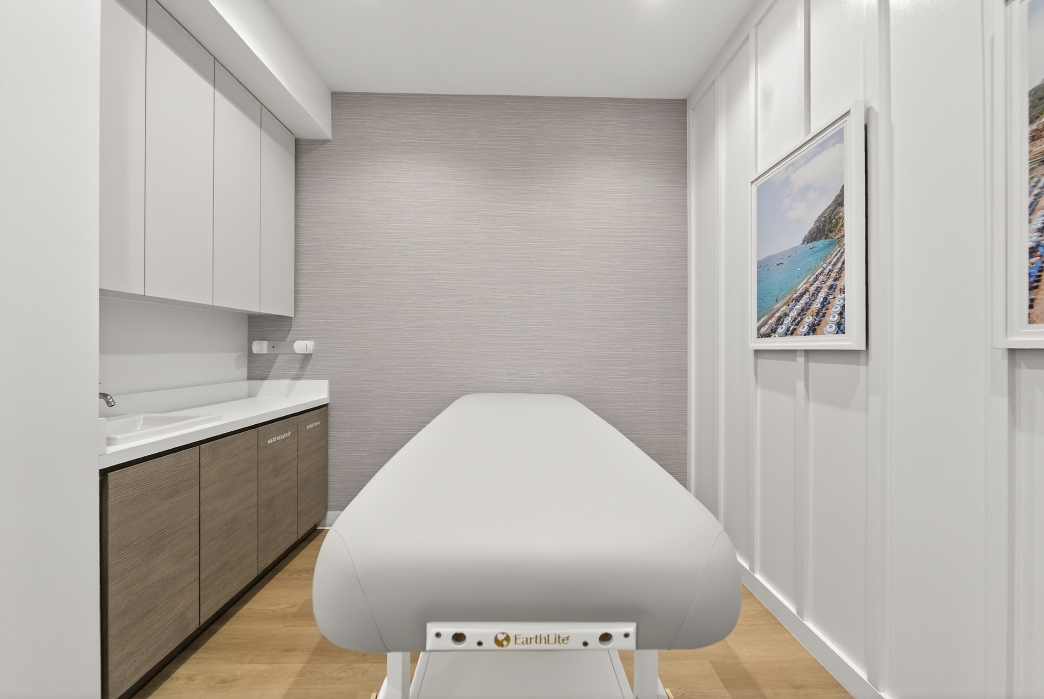 Treatment bed and cabinetry in a bright treatment suite